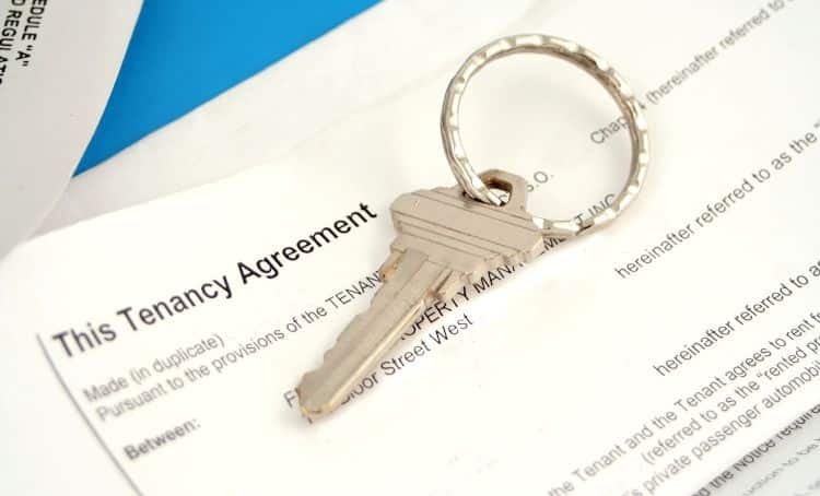 a key laying on a tenancy agreement - tenant improvement allowance