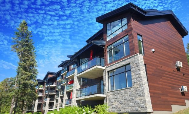 A wood faced multi-family property with a pine tree in front - Express Capital Financing
