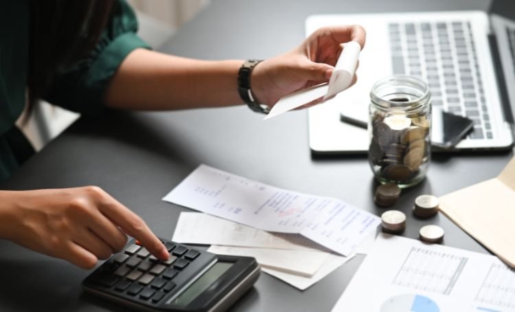 someone adding up receipts with a calculator - tenant improvement allowance
