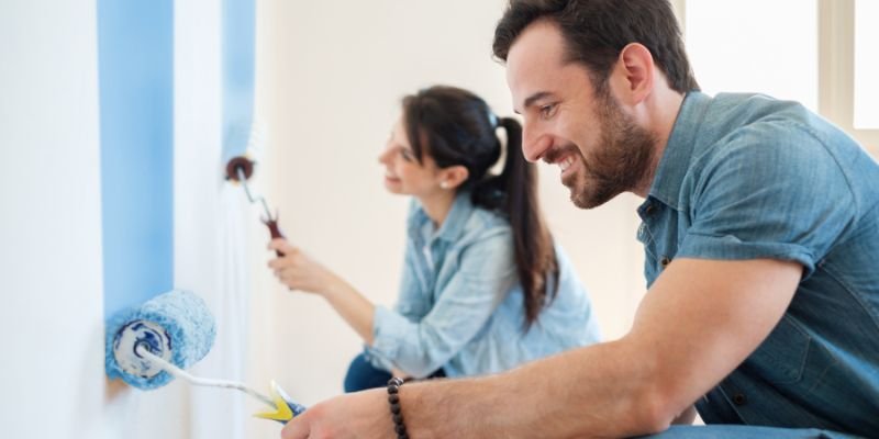 A couple painting the walls of their fix and flip property - ECF
