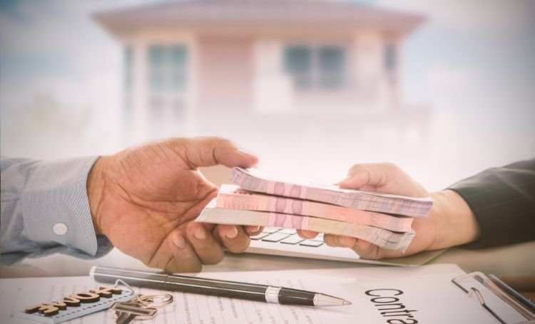 A lender handing over a hard loan to a property investor - ECF