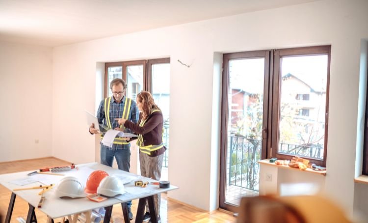 A couple reviewing their fix and flip plans wearing work gear - Express Capital Financing
