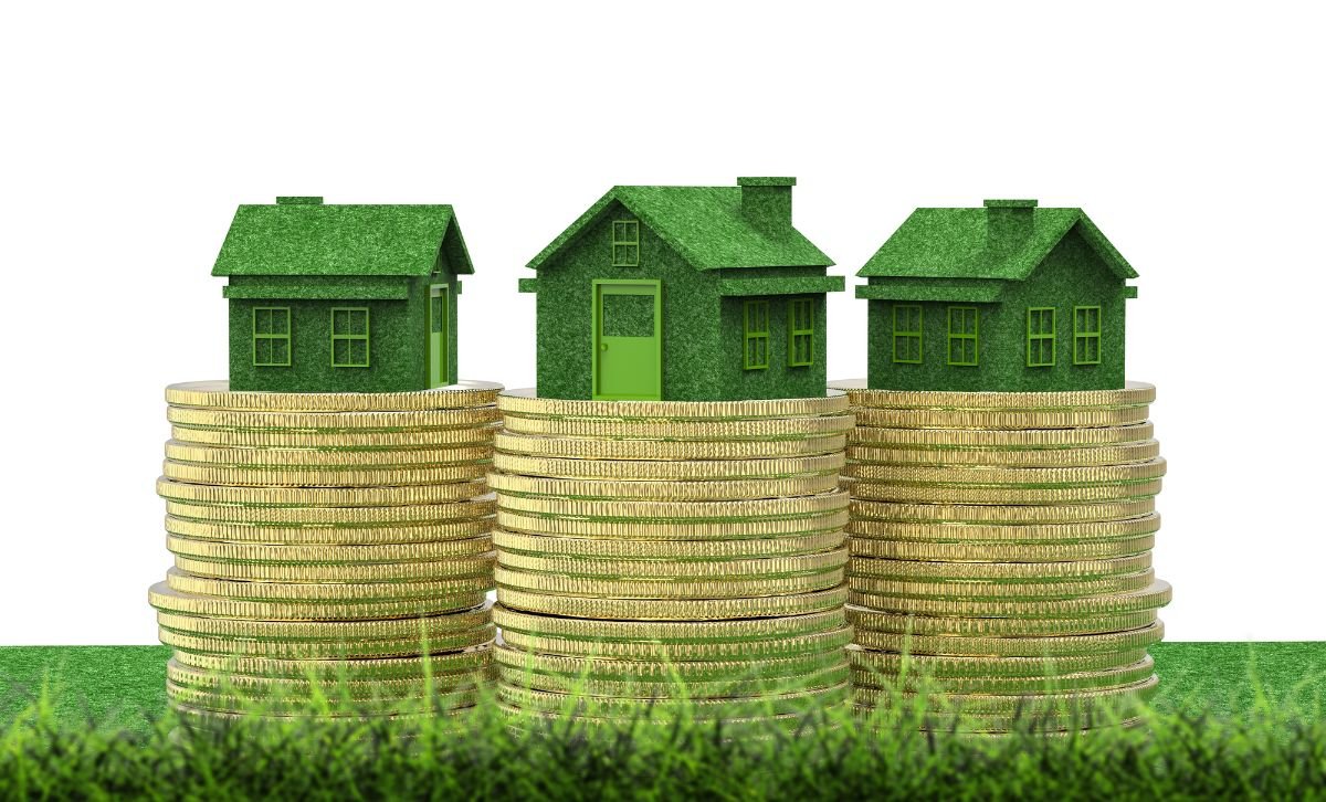 Three small models of houses sitting on top of three stacks of gold coins - Express Capital Financing