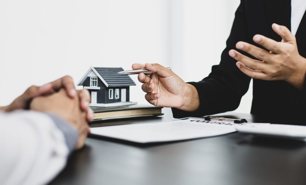 Two men discussing paperwork with a small house in the background - Express Capital Financing