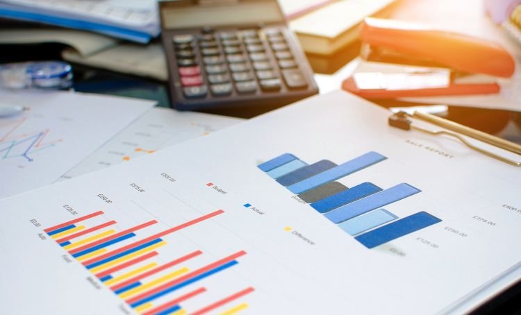 A calculator sitting on a sheet of paper displaying multi-colored graphs - Express Capital Financing