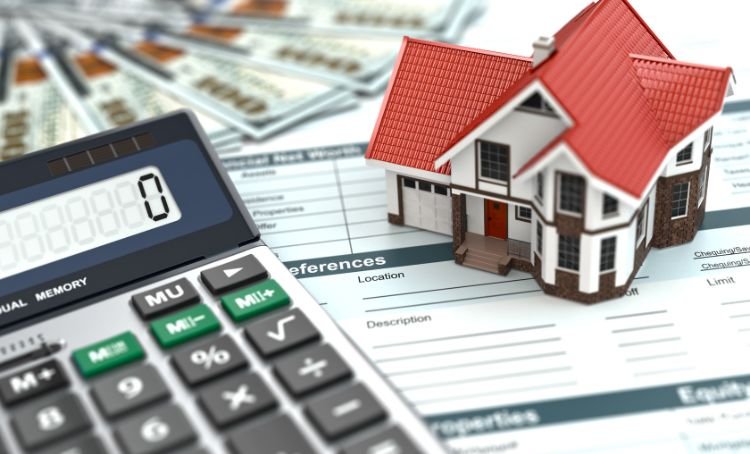 a calculator next to a small house - fix and flip property