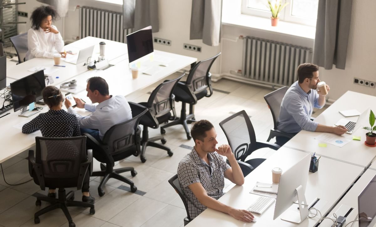 An overview shot of people sitting at desks in an open-plan office - Express Capital Financing