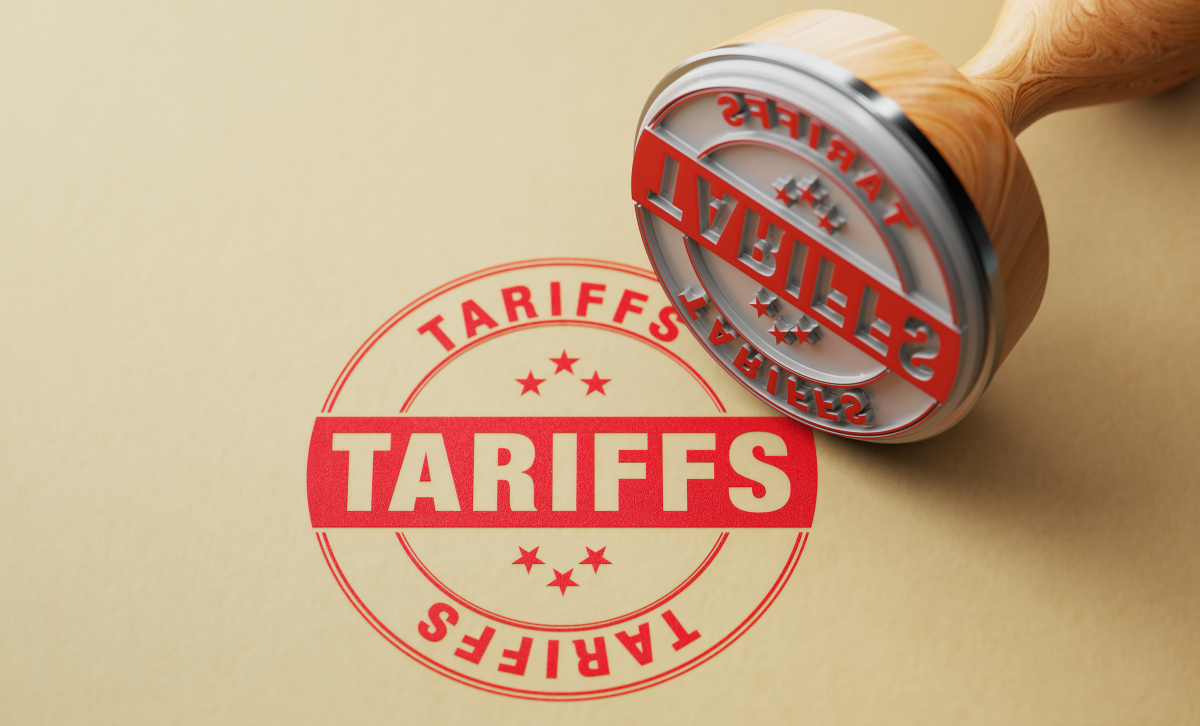 A rubber stamp next to a red stamp reading tariffs on a light brown background - Express Capital Financing