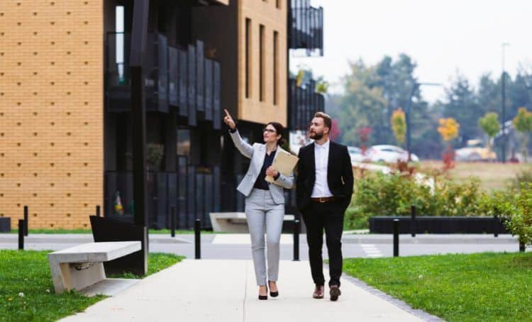 people walking down a path looking at buildings